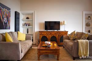 a living room with two couches and a coffee table at Wallace View Apartment in Stirling