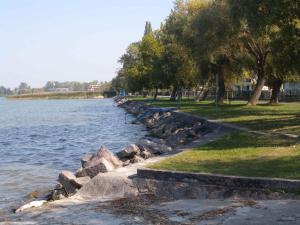 a row of rocks next to a body of water w obiekcie Apartment in Siofok/Balaton 27717 w Siófoku +4 zdjęcia