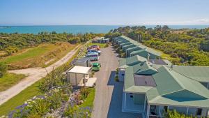 an overhead view of a row of houses with the ocean in the background at Omau Settlers Lodge Motel in Westport