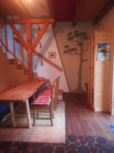 Holiday home in Trebbin 2611 في Trebbin: طاولة وكراسي خشبية في غرفة بها درج