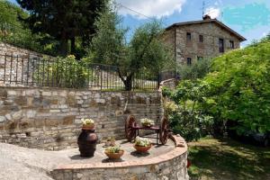 a stone wall with potted plants and a stone bench at Apartment in Bagno a Ripoli/Toskana 23871 in Villamagna