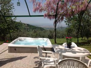 a hot tub sitting on a patio with a table and chairs at Apartment in Bagno a Ripoli/Toskana 23871 in Villamagna