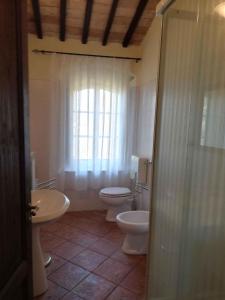 uma casa de banho com 2 WC, um lavatório e um chuveiro em Holiday home in Montalcino/Toskana 24097 em Montalcino