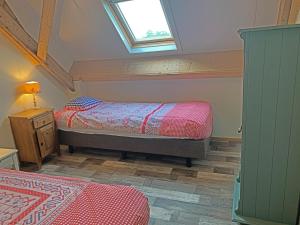a attic bedroom with two beds and a window at Christinahoeve Oude Deel #4 in Boskoop