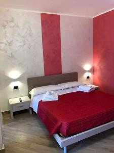 una camera con un letto con una parete rossa e bianca di Apartment in Palmi/Kalabrien 21007 a Palmi