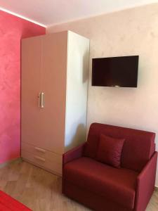 un soggiorno con divano rosso e armadio di Apartment in Palmi/Kalabrien 21007 a Palmi