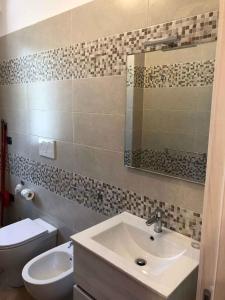 bagno con lavandino, servizi igienici e specchio di Apartment in Palmi/Kalabrien 21007 a Palmi