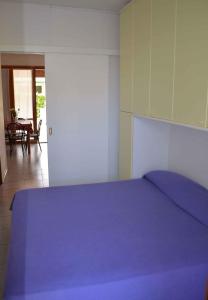 エラクレア・マーレにあるApartments in Eraclea Mare 25804のベッドルーム(紫の毛布付きのベッド1台付)