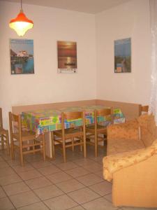 een woonkamer met een tafel en stoelen en een bank bij Apartment in Rosolina Mare 24985 in Rosolina Mare