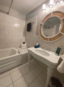 a bathroom with a sink and a tub and a mirror at Tilghman Island Inn in Tilghman Island