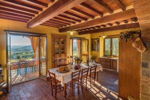uma cozinha com mesa e cadeiras e uma varanda em Holiday home in Castiglion Fiorentino 23605 em Castiglion Fiorentino