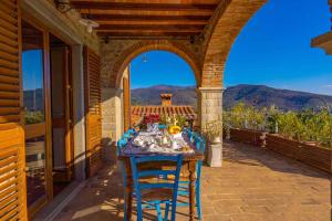 uma mesa num pátio com vista para as montanhas em Holiday home in Castiglion Fiorentino 23605 em Castiglion Fiorentino
