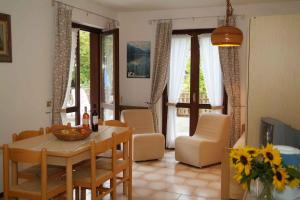 a kitchen and dining room with a table and chairs at Apartments Molina di Ledro/Ledrosee 22633 in Mezzolago