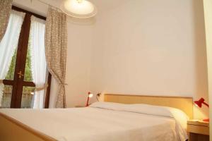 a bedroom with a white bed and a window at Apartments Molina di Ledro/Ledrosee 22633 in Mezzolago