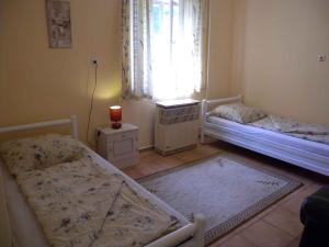 Cette chambre comprend deux lits et une fenêtre avec une bougie. dans l'établissement Apartment in Balatonbereny 18127, à Balatonberény