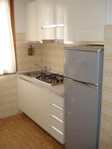 una cucina con frigorifero in acciaio inossidabile e lavandino di Apartment in Porto Santa Margherita 25147 a Porto Santa Margherita di Caorle