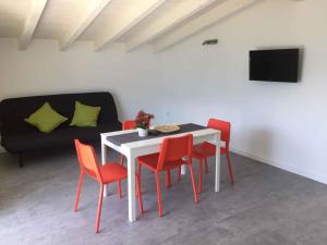 特雷莫西内Apartments in Tremosine - Gardasee 34618的一张带红色椅子的白色桌子和一张黑色沙发