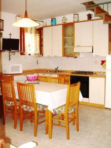 Una cocina con una mesa y sillas y un fregadero. en Apartment in Rosolina Mare 33096, en Rosolina Mare