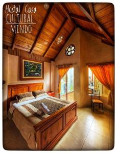 um quarto com uma cama grande num quarto em Hostal Casa Cultural Mindo em Mindo