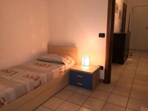 um quarto com uma cama e um candeeiro numa mesa de cabeceira em Apartment in Bardolino/Gardasee 21881 em Bardolino