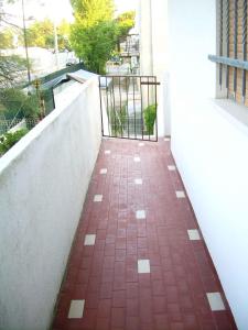 Una pasarela de ladrillos rojos con una puerta en un balcón. en Apartment in Rosolina Mare 33096, en Rosolina Mare 1 foto más