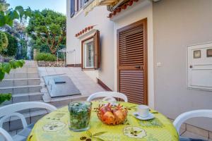 einen gelben Tisch mit einer Schale Obst auf einer Terrasse in der Unterkunft Apartment in Mali Losinj 15009 in Mali Lošinj