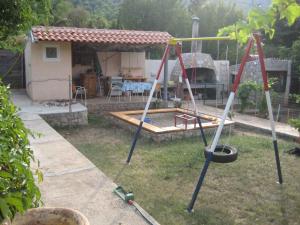 a swing set in a yard with a house at Apartment in Veli Losinj 26456 in Veli Lošinj
