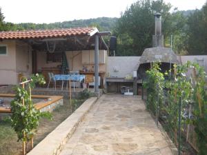 an outdoor kitchen with a pizza oven in a yard at Apartment in Veli Losinj 26456 in Veli Lošinj