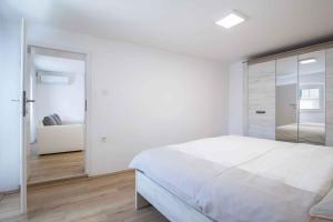 een witte slaapkamer met een bed en een bank bij Holiday home in Medulin/Istrien 36032 in Medulin