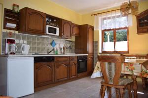 cocina con armarios de madera y nevera blanca en Apartments in Bublava/Erzgebirge 1704 en Bublava