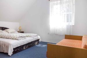 1 dormitorio con cama, ventana y silla en Holiday home in Balatonmariafürdo 35399 en Balatonmáriafürdő
