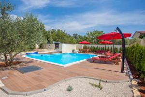 a swimming pool with a red umbrella and a patio at Apartment in Nova Vas - Istrien 35437 in Nova Vas