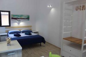 a bedroom with a bed with blue pillows at Studio in Siracusa/Insel Sizilien 34738 in Siracusa