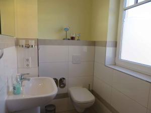 a bathroom with a sink and a toilet and a window at Apartment in Börgerende-Rethwisch 34953 in Börgerende-Rethwisch