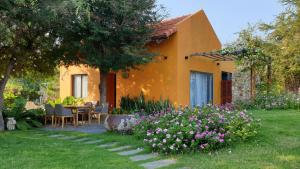 ein Haus mit einem Tisch und Blumen im Hof in der Unterkunft Lotus Beach House in Phan Thiet