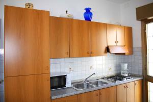 una cocina con armarios de madera y fregadero en Studio in Lignano Sabbiadoro 31382, en Lignano Sabbiadoro