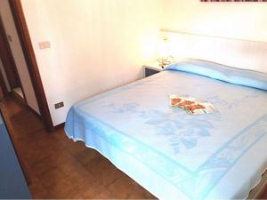 a bedroom with a bed with a book on it at Apartments in Bibione 35340 in Bibione