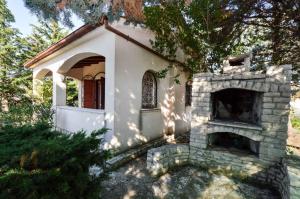 uma pequena casa com lareira de tijolos no quintal em Holiday home in Medulin/Istrien 35448 em Medulin