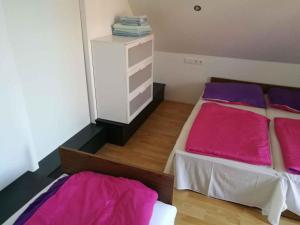 ギェネシュディアーシュにあるHoliday home in Gyenesdias/Balaton 33973のベッドルーム1室(ピンクと紫のシーツが備わるベッド2台付)