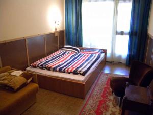 ein Schlafzimmer mit einem Bett, einem Sofa und einem Fenster in der Unterkunft Holiday home in Szantod/Balaton 31357 in Szántód