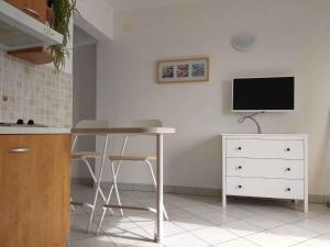 una cucina con tavolo e TV a parete di Apartments in Njivice/Insel Krk 34038 a Njivice