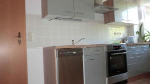 eine Küche mit einem Kühlschrank aus Edelstahl und einem Herd in der Unterkunft Apartment in Ribnitz-Damgarten 35179 in Ribnitz-Damgarten