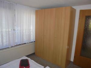 WartheにあるApartment in Rankwitz OT Warthe 34765のベッドルーム1室(窓の横に大きな木製キャビネット付)