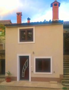 a white house with two windows and a door at Holiday home in Krsan 34373 in Kršan