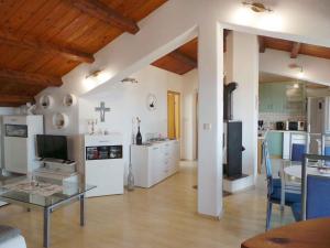 a living room with a glass table and a kitchen at Apartment in Lovran 34848 in Lovran
