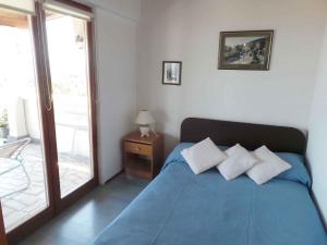 a bedroom with a blue bed and a window at Apartment in Lovran 34848 in Lovran