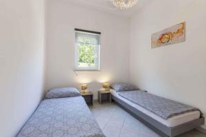 2 camas individuales en una habitación con ventana en Holiday home in Drenje/Istrien 34626, en Drenje
