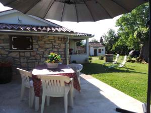 - une table et des chaises avec un parasol sur la terrasse dans l'établissement Holiday home in Krsan 34600, à Kršan