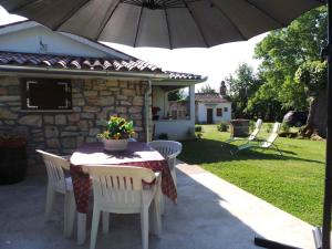 a table and chairs with an umbrella on a patio at Holiday home in Krsan 34600 in Kršan
