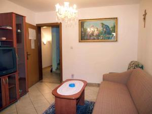 ein Wohnzimmer mit einem Sofa und einem Gemälde an der Wand in der Unterkunft Apartment in Omisalj/Insel Krk 34661 in Omišalj